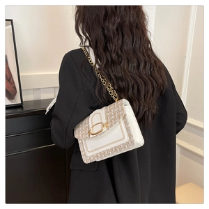 Détail du sac bandoulière en tweed et cuir avec anneau doré et chaîne élégante