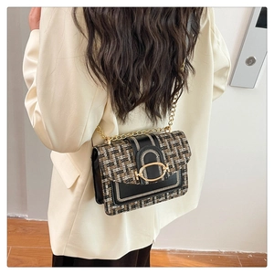 Détail d'un sac chaîne en tweed porté sur un blazer, montrant taille et texture