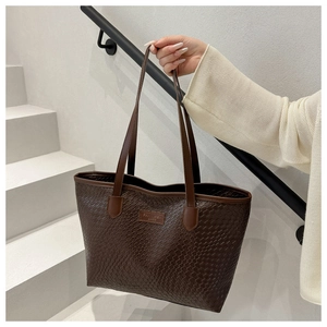Dettaglio della trama intrecciata marrone scuro e logo su una borsa a tracolla
