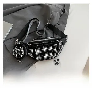 Détail du sac de selle noir à rivets avec mini porte-monnaie rond et bandoulière rayée