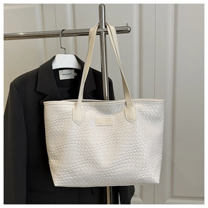 Dettaglio della borsa tote intrecciata bianca con spalline sottili e logo in pelle