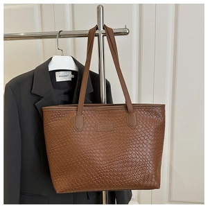 Dettaglio della borsa tote intrecciata marrone caffè con logo FANYISSA e pelle intrecciata