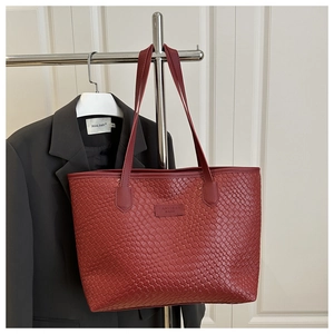Dettagli della trama in pelle intrecciata bordeaux della borsa tote appesa al supporto