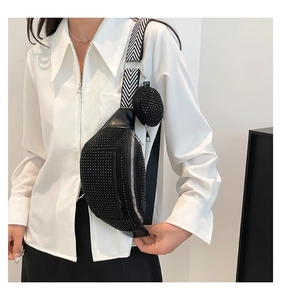 Detail of black studded crossbody bag with wide striped strap and mini coin purse