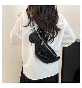 Close-up of black studded crossbody bag with round coin purse and striped wide strap