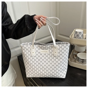 Detail of white tote bag with grey M patterns and a fashion leather patch label