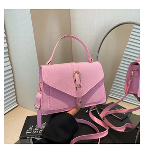Pink shoulder bag detail showing textured diagonal fabric and golden horseshoe clasp