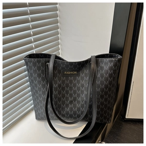Close-up of the large tote bag showing all-over M pattern and gold fashion label detail