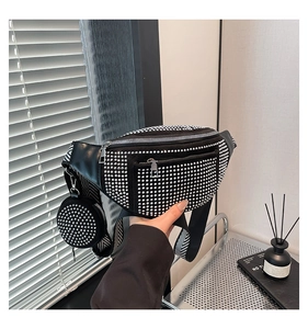 Detail of black crossbody bag with silver rhinestones and chevron woven wide strap
