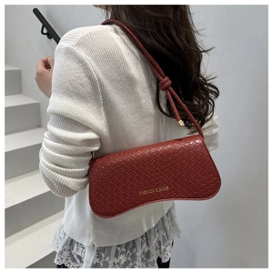 Détail du sac à bandoulière bordeaux motif crocodile avec lettrage doré de la marque