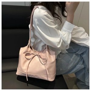 Close-up of soft pink faux leather shoulder bag with delicate bow knot detail