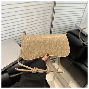 Détail de la texture en cuir de crocodile embossé abricot sur un petit sac à main carré
