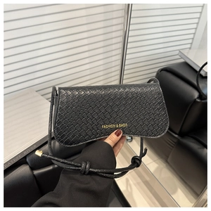 Détail du sac bandoulière noir en cuir croco avec lettrage doré et bandoulière nouée