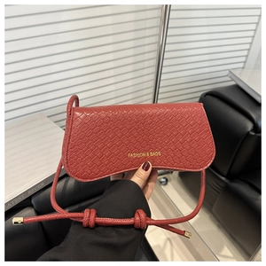 Détail du sac en cuir gaufré crocodile marron rouge avec base courbe et nœud