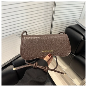 Détail du sac à bandoulière marron foncé motif crocodile avec logo doré et nœud
