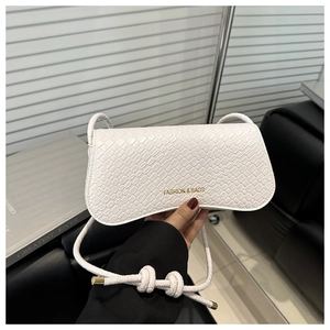 Détail d'un sac à main blanc texture crocodile avec lettrage doré et sangle tressée