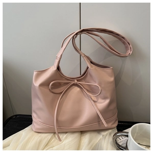 Detail of a dusty rose pink tote bag featuring a decorative bow and smooth PU leather texture