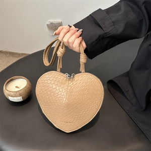 Crocodile embossed heart-shaped crossbody bag in beige with knotted handle and dual zipper