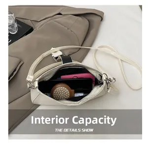 Interior view of off-white shoulder bag showing storage capacity for phone and wallet