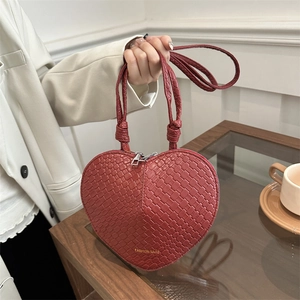 Red heart-shaped handbag with woven texture and top handle for elegant summer styling