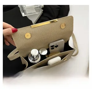 Detail van de binnenste capaciteit voor cosmetica en telefoon in een beige gevlochten tas