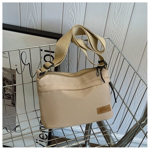 Detail of water-resistant beige crossbody bag with adjustable strap in metal basket