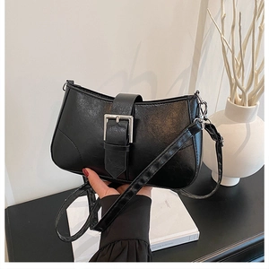 Detail of textured black faux leather bag with a striking square silver metal buckle