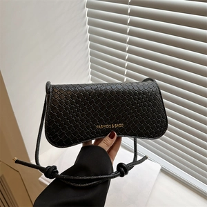 Sac à bandoulière noir tissé minimaliste avec texte doré présenté sous un angle manuel