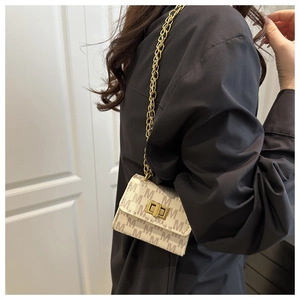 Detail of mini square chain bag with brown M-pattern and gold rectangular turn-lock