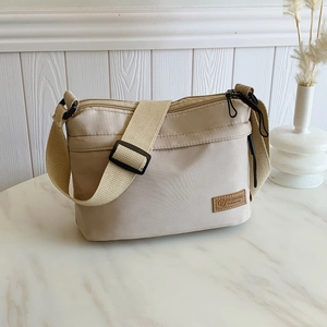Sac bandoulière imperméable en nylon kaki avec plusieurs zips et large sangle réglable