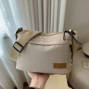Sac bandoulière en nylon beige avec compartiments multiples et large sangle réglable