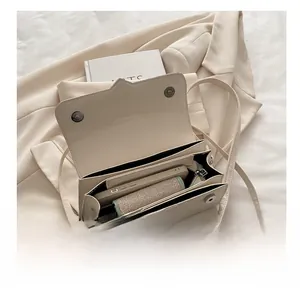 Interior view of cream crossbody bag showing functional compartments and storage capacity