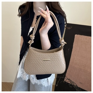 Gros plan du sac sous l'aisselle kaki avec texture tressée et détail de poignée nouée