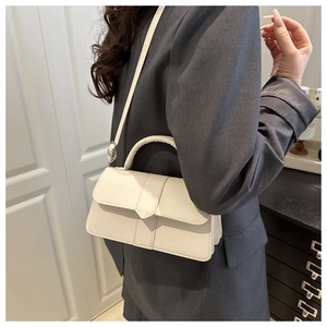 Model wearing a minimalist cream-white PU leather crossbody bag with a square flap design