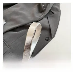 Detail of silver pearl texture shoulder strap on a minimalist faux leather crossbody bag