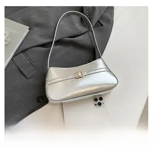 Silver metallic shoulder bag detail with gold buckle and size comparison with phone
