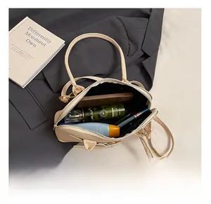 Top-down view of a beige bowling bag interior holding a phone and daily essentials