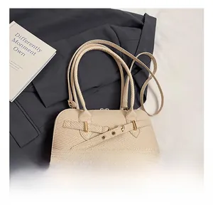 Detail of light beige woven texture on luxury PU leather pillow bag with gold hardware