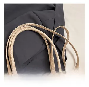 Close-up of beige woven texture pillow bag with soft handle and light gold metal zipper