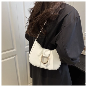 Detail of white matte leather shoulder bag with a prominent golden D-shaped metal buckle