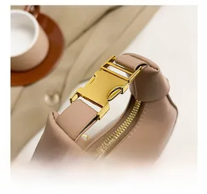 Detail of elegant handbag showing the golden buckle and smooth leather handle finish