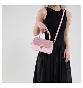 Detail of pink tweed flap shoulder bag with gold twist lock on black dress