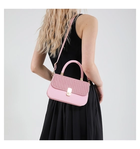 Pink crossbody bag with glitter flap detail and gold buckle shown on a model