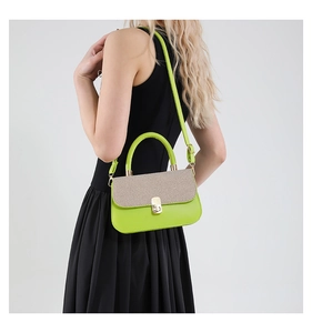 Fashionable contrast color lime green and beige shoulder bag worn by model in black dress