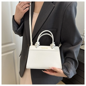 Detail of white leather tote featuring knotted handle and gold Fashion Bag logo