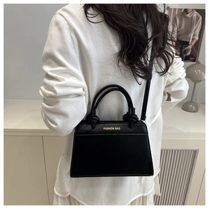 Detail view of the black crossbody tote bag showing the gold Fashion Bag logo and slim strap