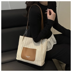 Fashionable woven tote bag in cream white with brown leather pockets and metal chain straps