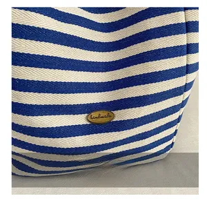 Macro shot of blue and white striped fabric texture with a handmade metal plate detail