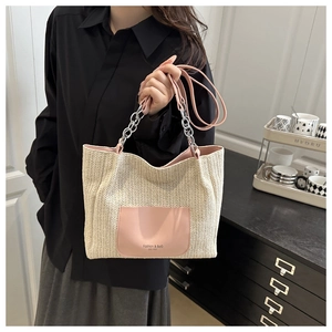 Detail of woven beach tote showing pink leather pocket and metal chain handle