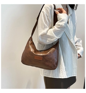 Detail of dark brown retro crescent shoulder bag showing textured PU leather and FASHION tag